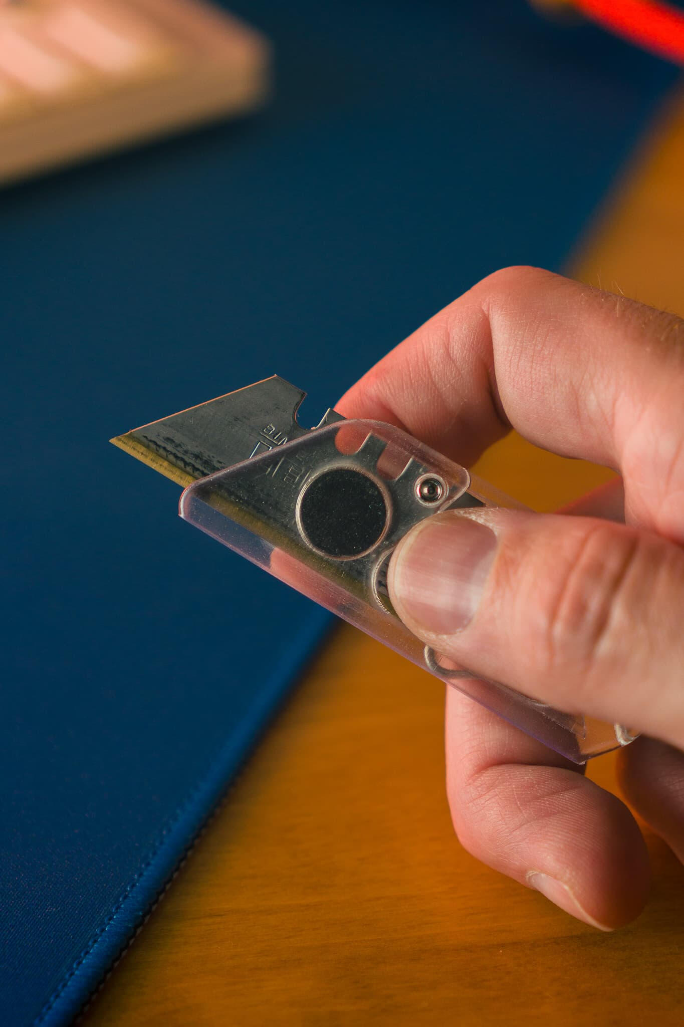 Clicky Cutter – Retractable EDC Box Cutter Click Feature Clicky Cutter compact retractable EDC box cutter showing satisfying click feature on blue surface