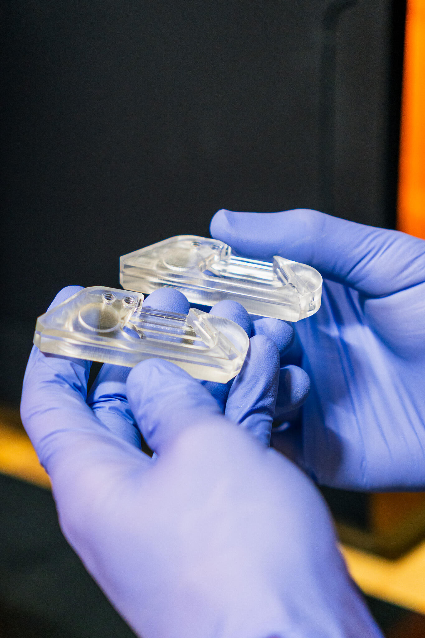 Hands holding two Clicky Cutter box cutters showing compact size